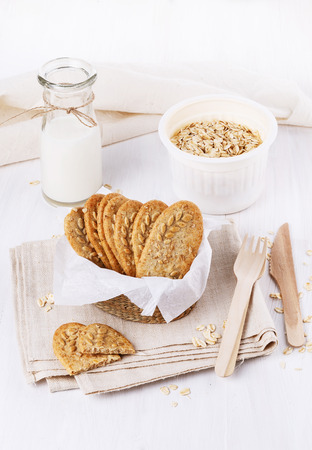 Healthy breakfast with wholegrain cookies and bottles of milk over white wooden backgroundの写真素材