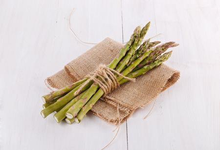 Bunch of fresh asparagus on a white rustic wooden backgroundの写真素材