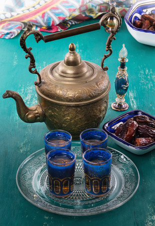 Middle Eastern tea and Ramadan date palm over turquoise wooden backgroundの写真素材