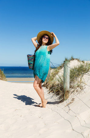 Beautiful women in resort clothing enjoying her holidays at the beachの写真素材