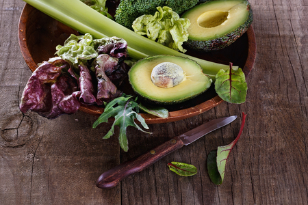 Group of green vegetables on a plate over rustic wooden backgroundの写真素材