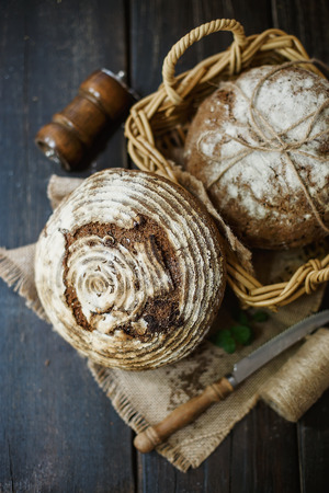 Sourdough artisan bread with spices on a rustic wooden background. Selective focus, Shallow depth of field, Rustic style imageの写真素材
