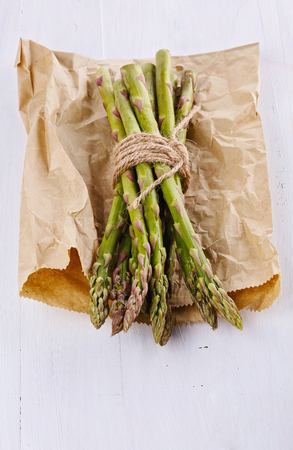 Bunch of fresh asparagus on a white wooden backgroundの写真素材