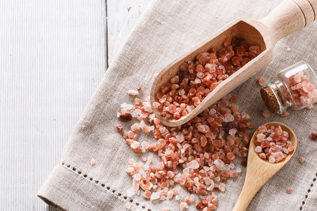 Himalayan pink salt on a linen cloth over white wooden background. Rustic styleの写真素材