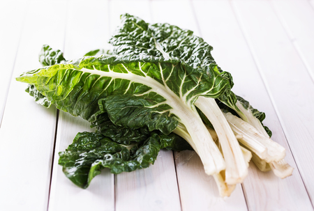 Bunch of organic silverbeet on a white wooden background. Selective focusの写真素材