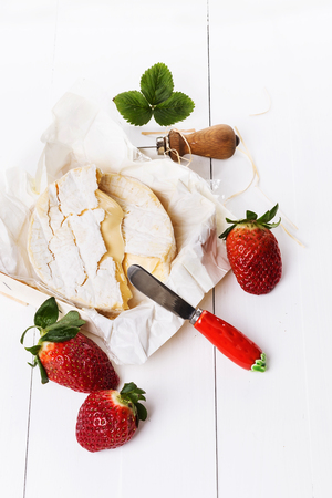 Fresh strawberries and cheese on a white wooden tableの写真素材