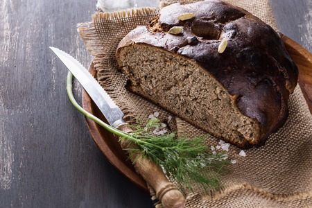 Homemade rye bread with dill and salt on a rustic wooden backgroundの写真素材