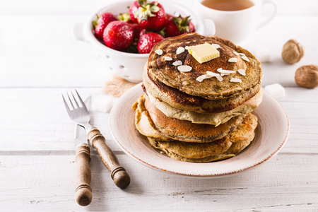 Pancakes, strawberries and tea over white wooden background close upの写真素材