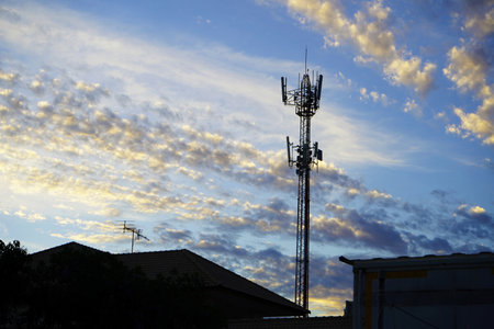 the evening sky, the sun is setting beautiful clouds behind radio towers.の写真素材