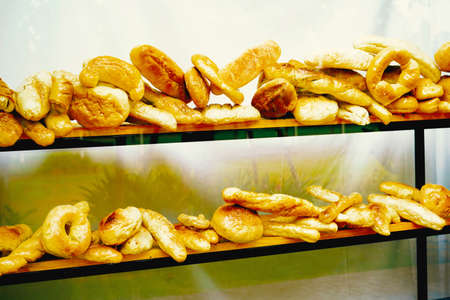 Various kinds of bread are in the glass cabinet shelf.の写真素材