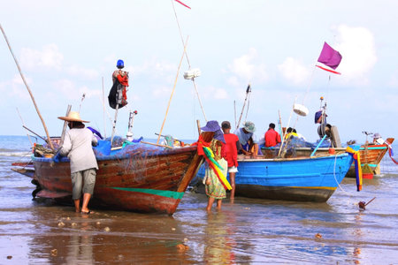 Fishermen check and repair broken fishing nets before going fishing by local boats.の写真素材