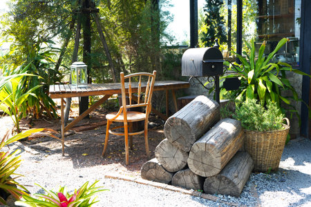 Decorate a vintage log bench next to a wooden table and chairs in the front garden.の写真素材