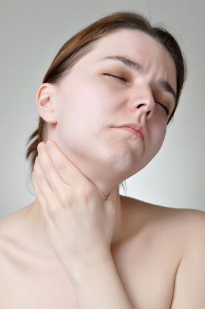 Young woman holding her painful throatの写真素材