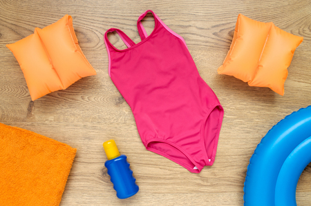 Little girl's summer vacation accessories on wooden floorの写真素材