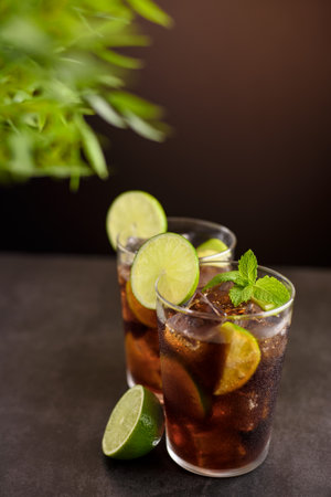 Cuba Libre cocktail. Alcoholic drink with cola, rum, lime and mint. Cuba Libre or long island iced tea cocktail.の写真素材