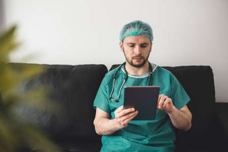 Doctor looking at tablet in the resting roomの写真素材