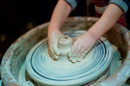 Child sculpts from clay pot. Workshop on modeling on the potterの写真素材