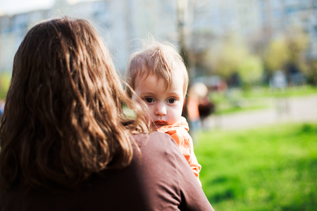 Little boy at  hands of mother. The baby is due to shoulder mothの写真素材