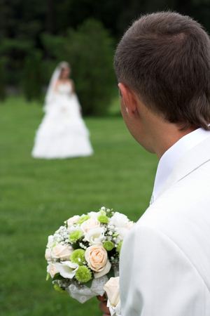 Bouquet of white roses in the hands of the groomの写真素材