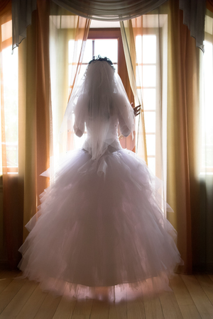 Bride in window opens curtainsの写真素材