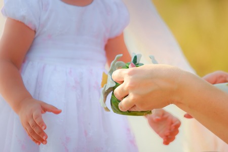 Mom holds a decorative kettle in hands. Mom and daughter are playing in kitchen.の写真素材