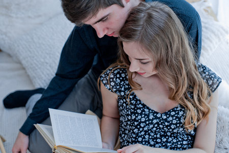 A guy with a girl read a book.