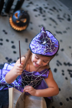 Swing the magic wand. Dressed in a carnival girl. Carnival costume of a witch. Witch's Hat. child...