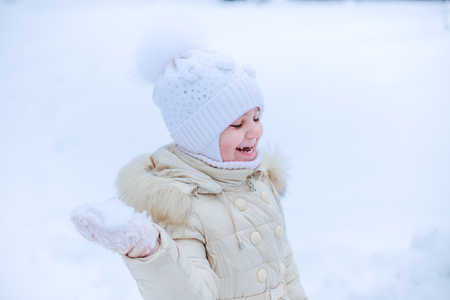 girls play snowballs in yard of kindergarten.の写真素材