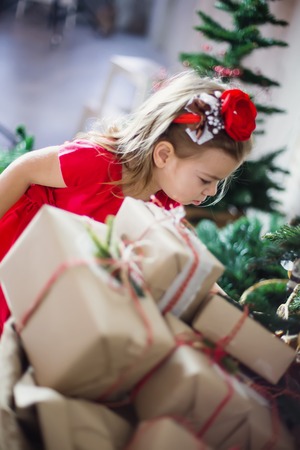 girl next to a bunch of gifts. Christmas gifts for Christmas.の写真素材