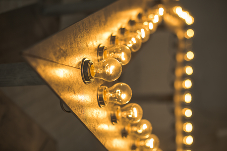 lamps on the star beam.decorative retro star with burning lights on grunge background. The loft style studio. Luminous lamps. Christmas decor.の写真素材