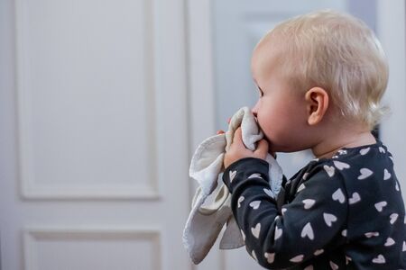 Little girl blows her nose holding a white handkerchief in her hands. The child blows his nose. Seasonal Allergy. Seasonal viral diseases in children. Chronic rhinitis, coryzaの写真素材