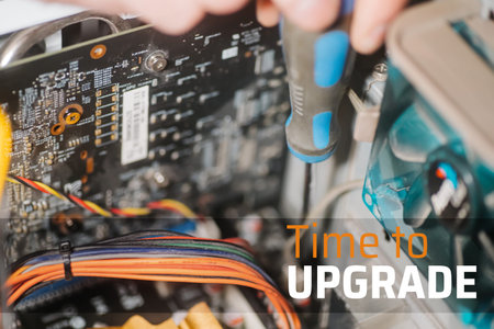 Text TIME TO UPGRADE. Installing motherboard with screwdriver. Professional man repairing and...