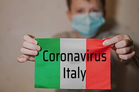 Text CORONAVIRUS ITALY on italian flag. Novel Coronavirus outbreak concept. Coronavirus protective breathing mask and glasses. 2019 nCoV virus infection originatingの写真素材