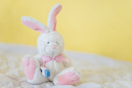 Toy Hare with electronic thermometer under paw. Measuring high temperature of children with influenza and viruses, coronavirus. Medicine conceptの写真素材