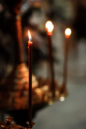 Three burning candles in Orthodox church.の写真素材