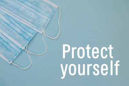 Three Surgical Ear-Loop mask. Protective medical mask on blue background. Framed in square. Coronovirus, quarantine, epidemic, pandemic, cold, illness. Medicine concept and health.の写真素材