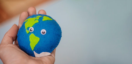 earth in woman's hand. homemade toy made of felt with oceans and land. Save the planet. World ocean day, saving water campaign. Cosept Earth Day.の写真素材