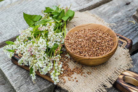 Dry uncooked buckwheat in wooden plate. Food for raw food and vegans. Ingredient for healthy food...