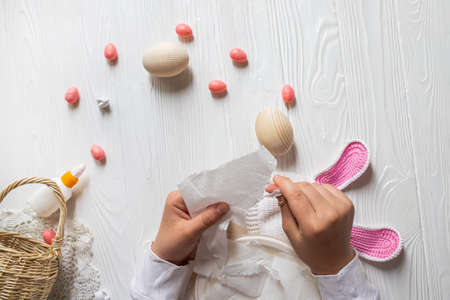 DIY ideas for creating an Easter decor. Step-by-step instruction of making eggs from papier mache. Step 4 Hands tearing paper napkin into pieces for sticking on an eggの写真素材