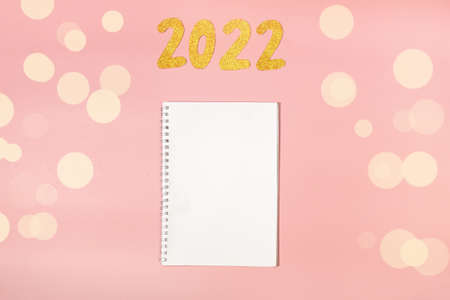 coming 2022 text on scattered dry buckwheat close-up. New Year for farmers. clean notebook on pink background. place for textの写真素材