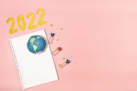 coming 2022 text on scattered dry buckwheat close-up. New Year for farmers. clean notebook on pink background. place for textの写真素材