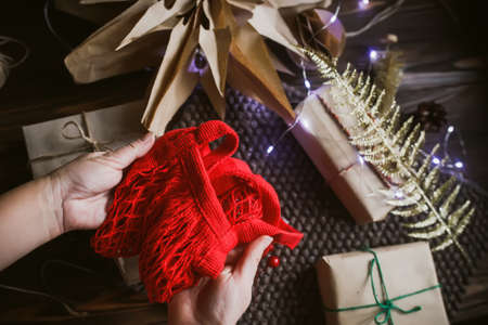 Bag red in a gift box made of craft paper against the background of Christmas decor. New Year 2022 wrapping gift conceptの写真素材