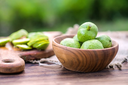Ingredients for tincture of green walnuts in a wooden ecological plate without chemicals on banner. zero waste. soft focusの写真素材