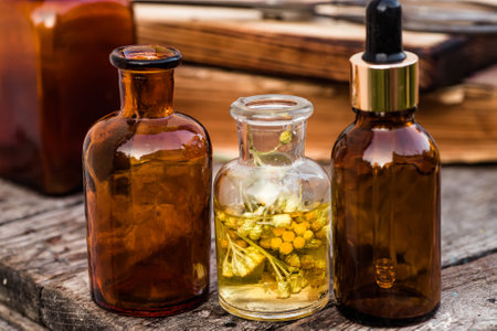 july arenarium, helichrysum arenarium, dwarf everlast, immortelle, curry plant, italian strawflower apothecary bottles with tincture and essential oils for beauty salons and alternative medicineの写真素材