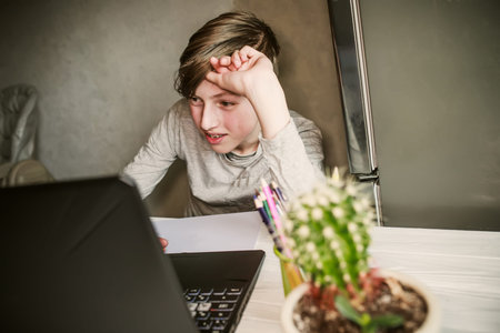 teenager working on a laptop computer at home office concept. back to school. Defocused