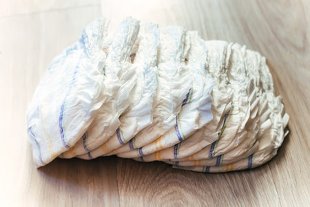 Scattered on the floor are a bunch of clean diapers. Personal hygiene items for spending money for a newborn. Non-washable disposable underwear.の写真素材