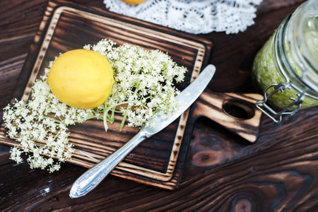 Grinding lemon and black elderberry on a cutting board to make an herbal drink or medicine for healing at home from syrup from elderberry flowersの写真素材