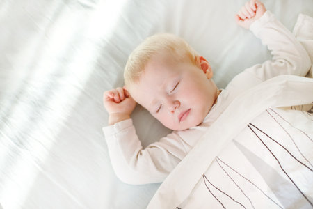 portrait of adorable baby girl sleeping in bed. baby napping during daytime sleep at home. Top view.の写真素材