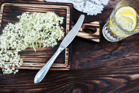 Grinding lemon and black elderberry on a cutting board to make an herbal drink or medicine for...