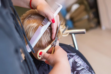 skilled hairdresser gives a child a stunning new haircut and style.の写真素材